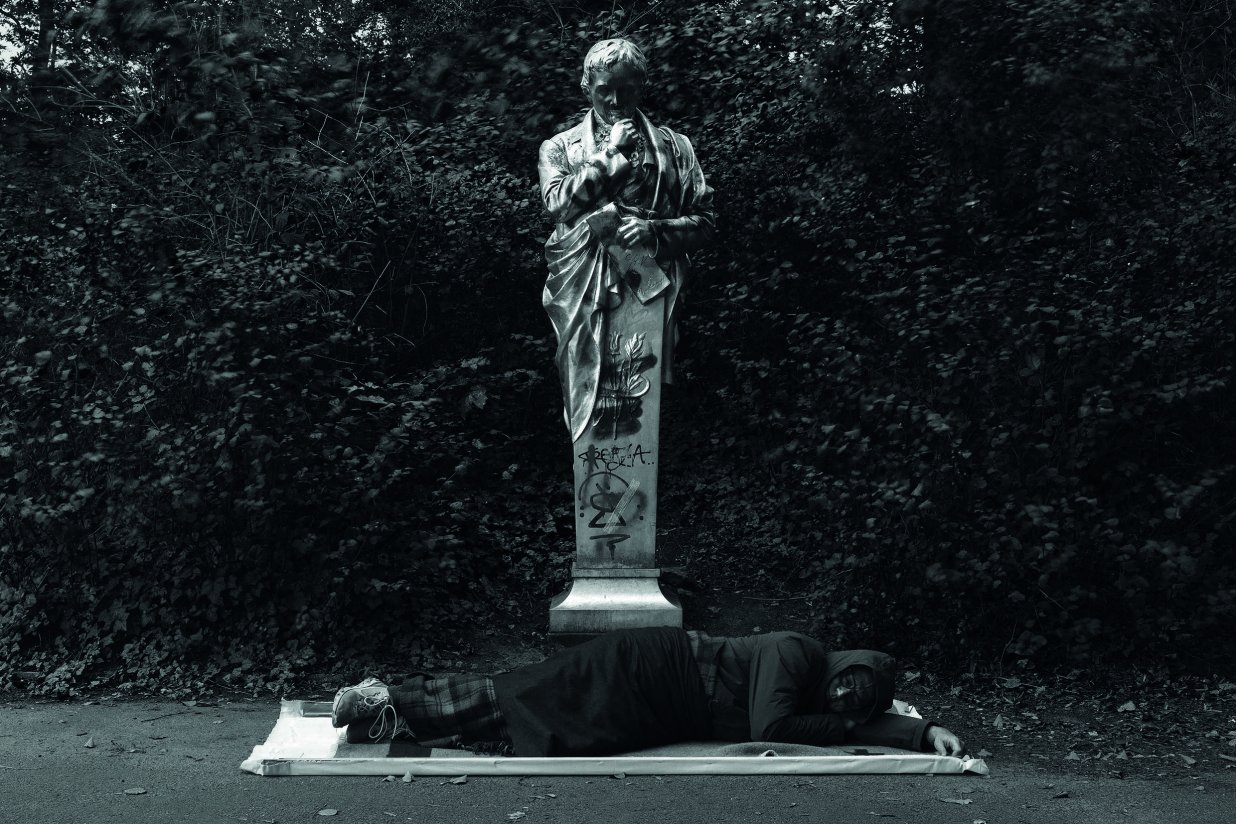 Das Bild zeigt den K&uuml;nstler Simon Wachsmuth w&auml;hrend einer Schlafperformance vor dem Heinrich von Kleist-Denkmal im Viktoria. | © CHROMA